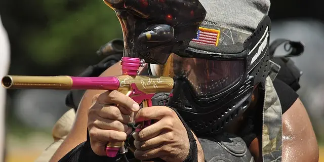 Joueur de paintball portant un masque de protection et tenant un pistolet à paintball
