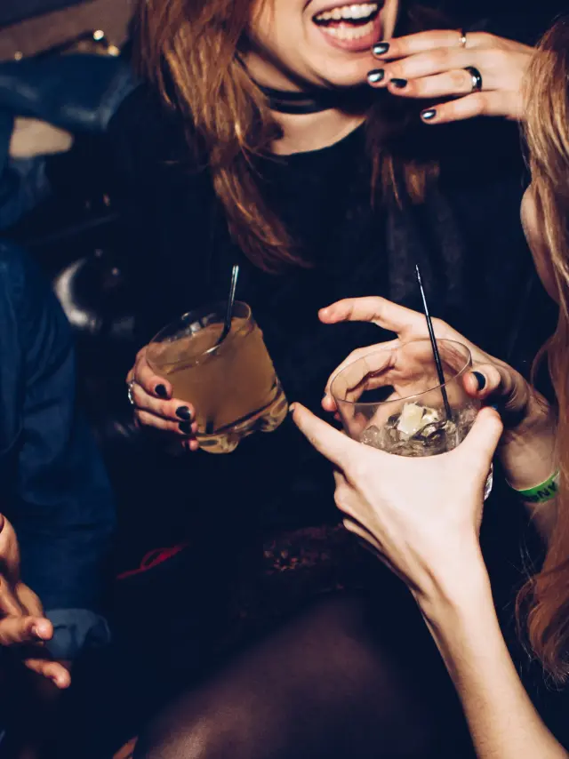 Groupe d'amis riant et buvant des cocktails