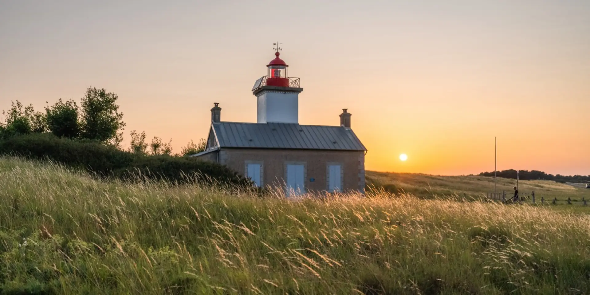 Red and white lighthouse at sunset