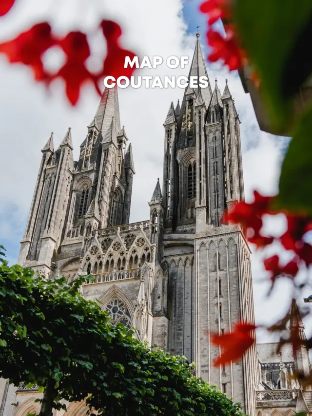 View of Coutances Cathedral with red flowers in the foreground