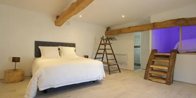 Chambre avec lit blanc, échelle en bois et grandes fenêtres aux Gabriolleries de Courcy
