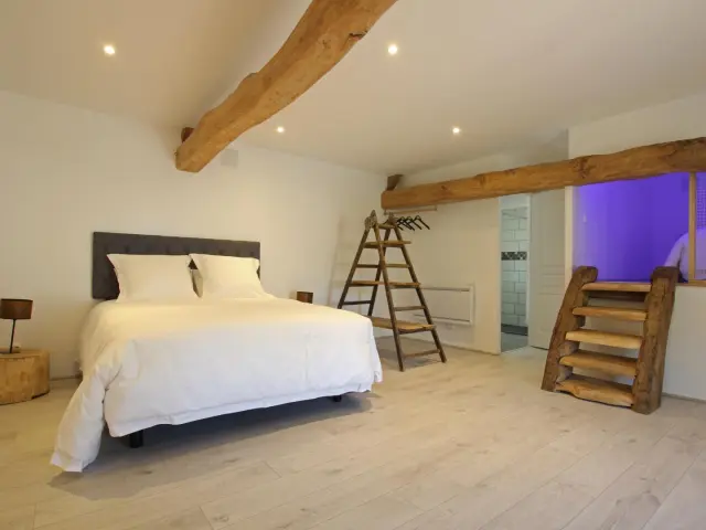 Chambre avec lit blanc, échelle en bois et grandes fenêtres aux Gabriolleries de Courcy