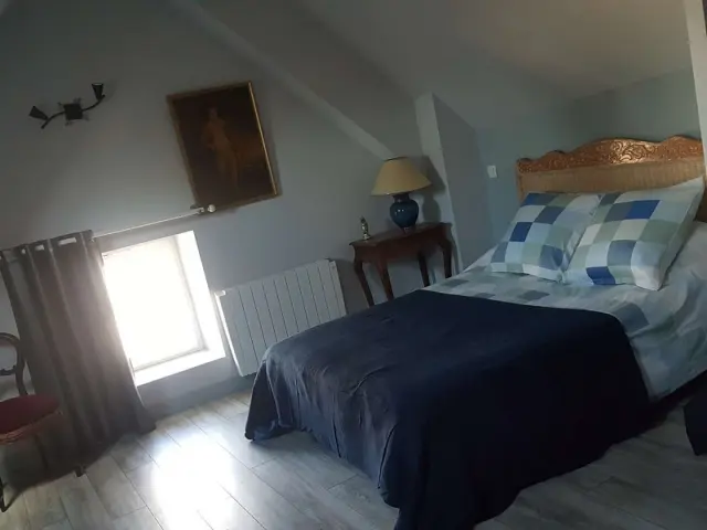 Chambre avec lit, table de chevet et radiateur : Chambres d'hôtes le Rey à Regneville sur Mer