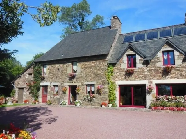 Maison en pierre avec des fleurs et des plantes grimpantes : Le clos Fleuri - Mme André