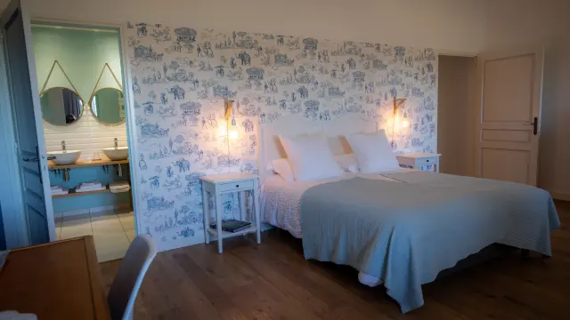 Chambre avec lit double, papier peint à motifs, et salle de bain attenante : Chambre d'hôtes Le Manoir des Loges