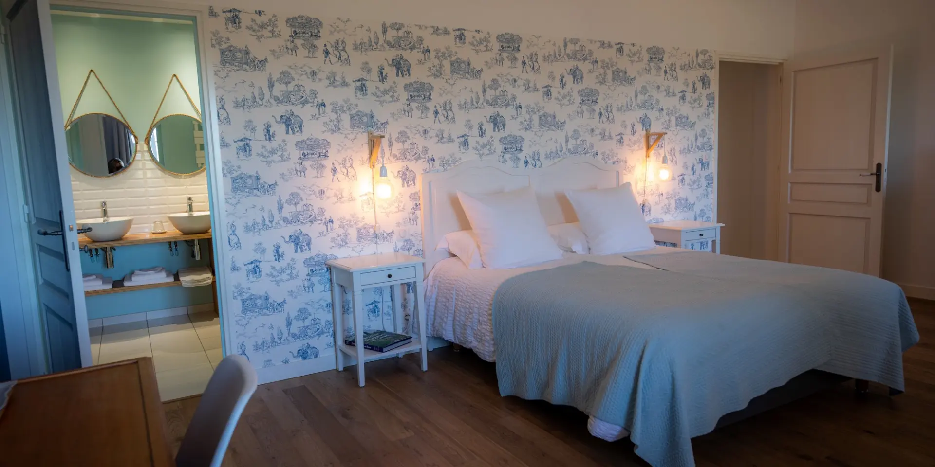 Chambre avec lit double, papier peint à motifs, et salle de bain attenante : Chambre d'hôtes Le Manoir des Loges