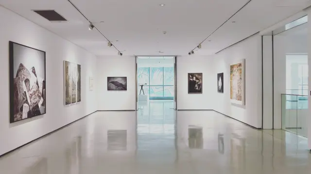 Galerie d'art avec des peintures accrochées aux murs et un sol en marbre poli