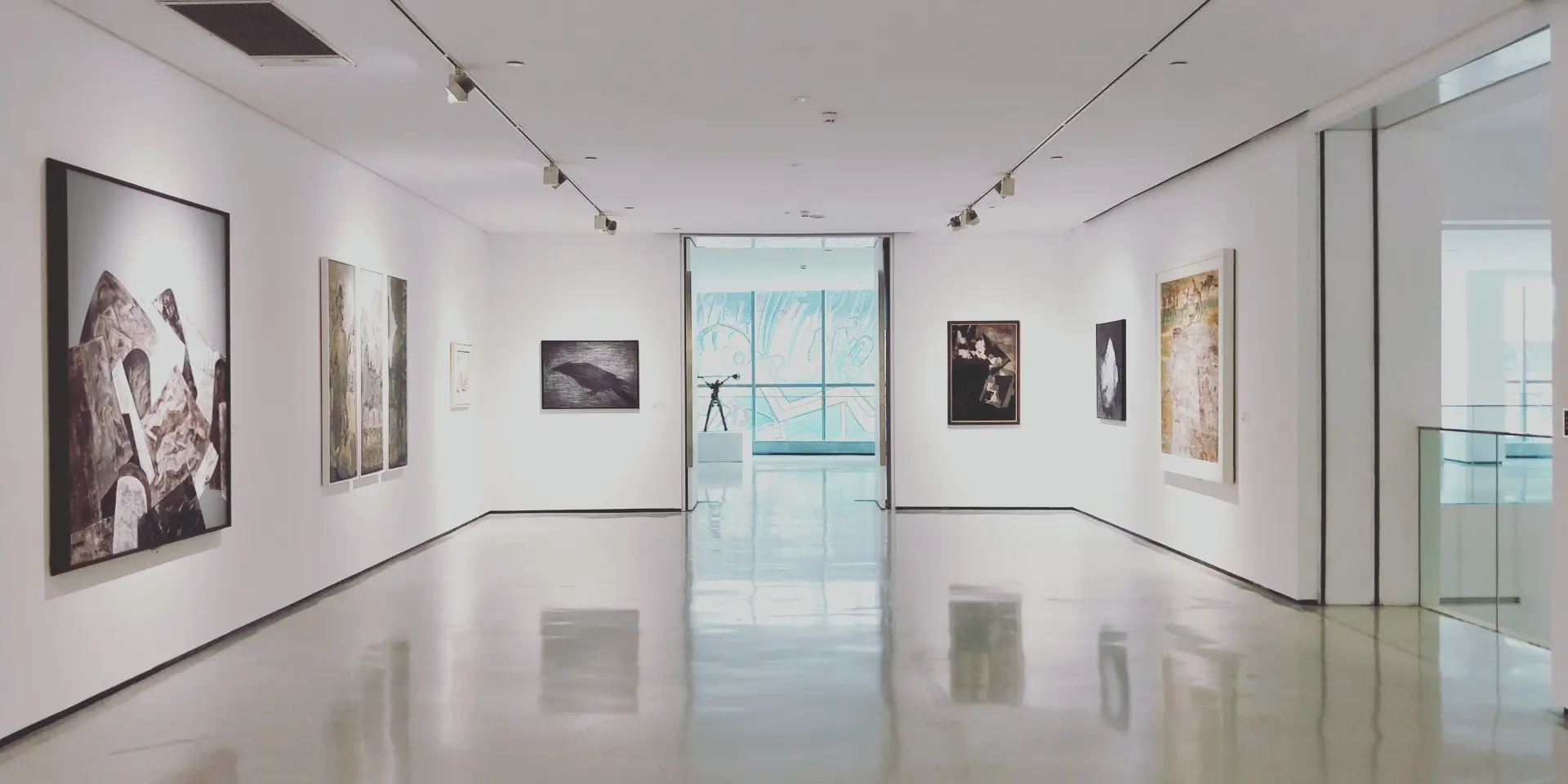 Galerie d'art avec des peintures accrochées aux murs et un sol en marbre poli