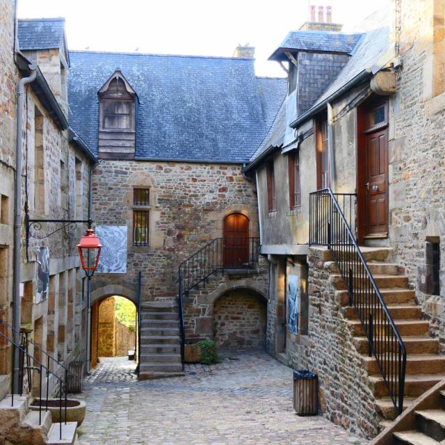 Medieval courtyard with stone stairs and stone buildings
