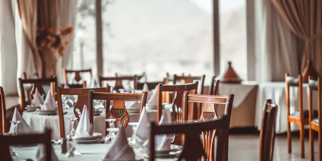 Salle à manger de restaurant avec tables soigneusement dressées et vue panoramique