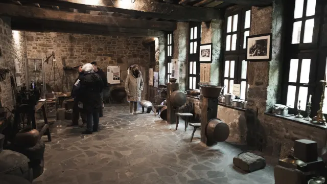 Stone workshop with people observing ancient instruments
