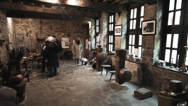 Stone workshop with people observing ancient instruments