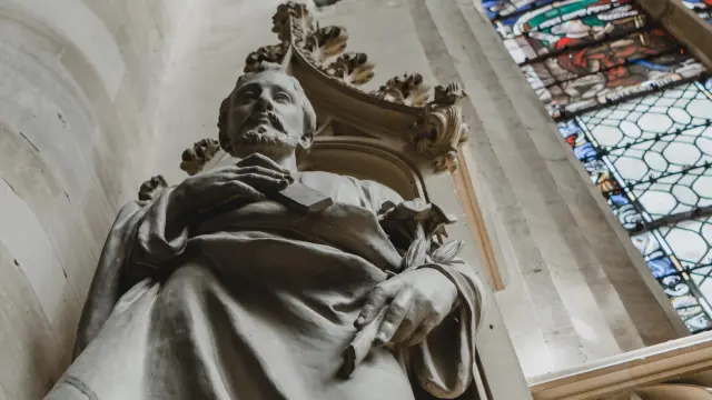Statue d'une figure religieuse en pierre avec une auréole dans la cathédrale de Coutances