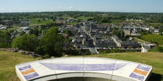 Panoramablick auf eine Stadt von einem Hügel mit einer Bank im Vordergrund