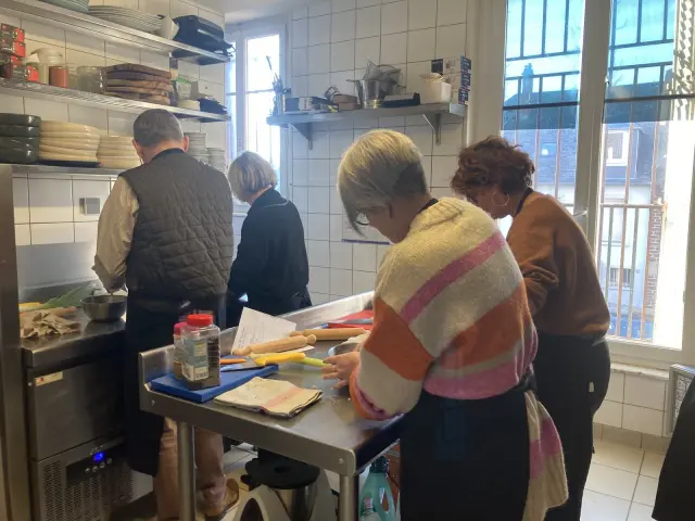 Personnes préparant de la nourriture dans une cuisine au restaurant A 3 pas