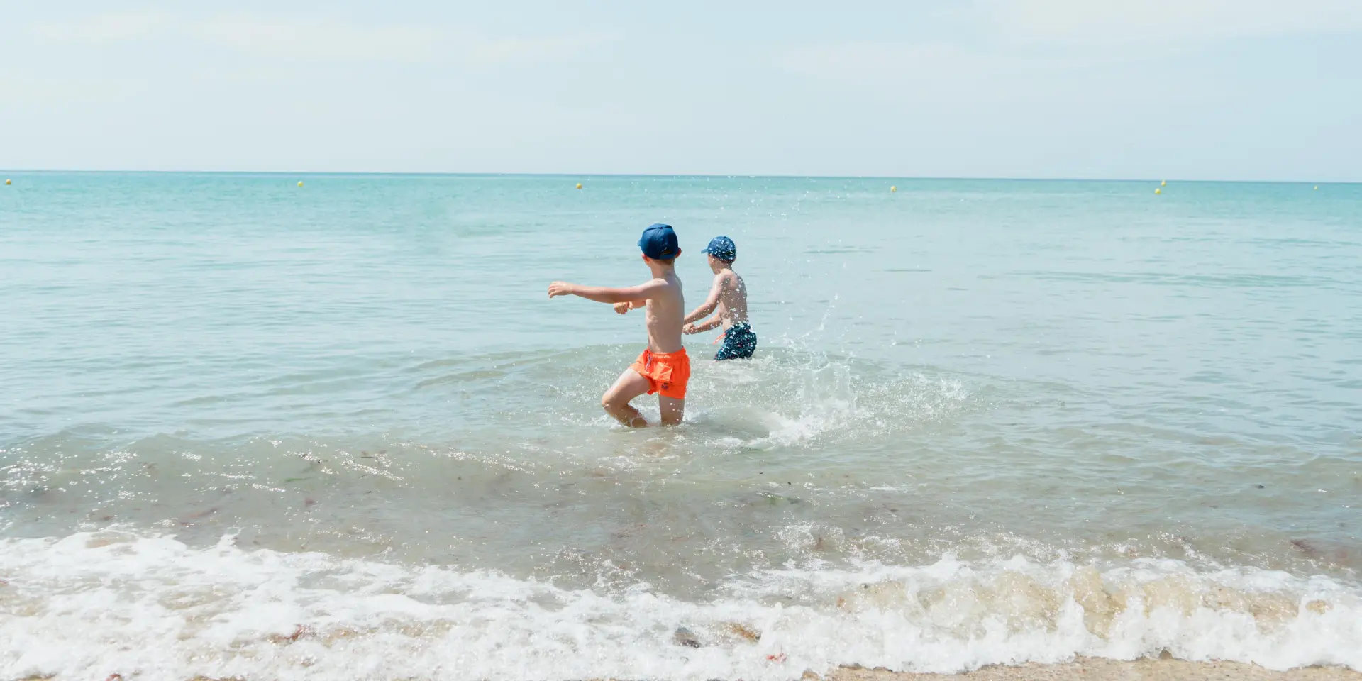 Deux enfants jouent dans les vagues de l'océan