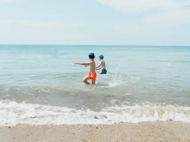 Deux enfants jouent dans les vagues de l'océan