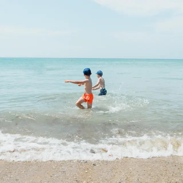 Deux enfants jouent dans les vagues de l'océan