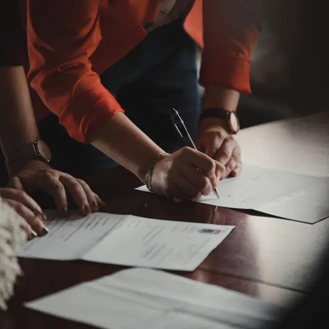 Deux personnes signent des documents sur une table