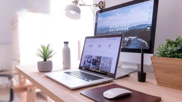 Bureau avec ordinateur portable, souris, lampe et plantes