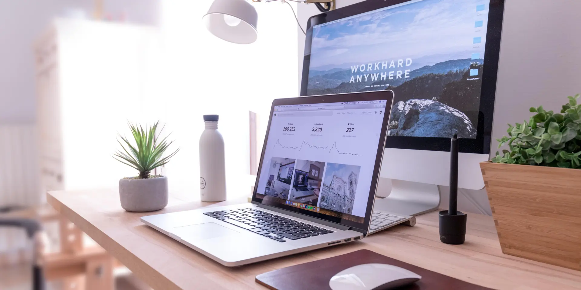 Bureau avec ordinateur portable, souris, lampe et plantes