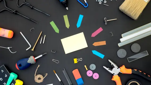 Divers outils et fournitures de bricolage disposés sur une surface noire