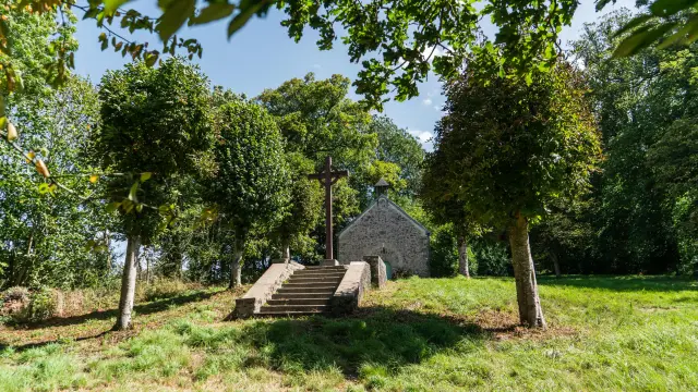 Stone chapel with a calvary at the top of a staircase
