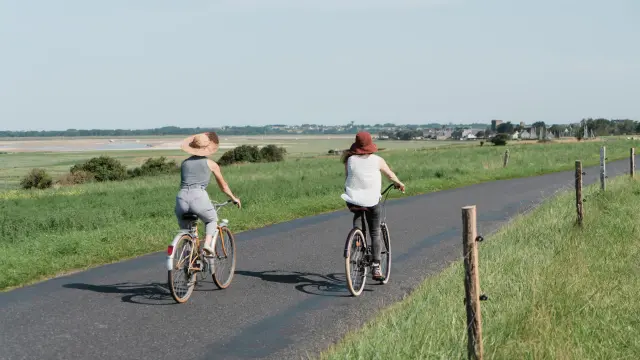 Deux personnes à vélo roulant sur une route de campagne