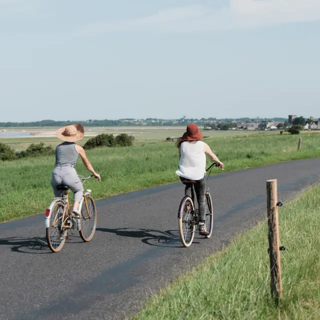 Deux personnes à vélo roulant sur une route de campagne
