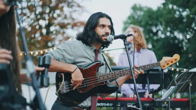 Un musicien jouant de la basse sur scène lors d'un concert en plein air