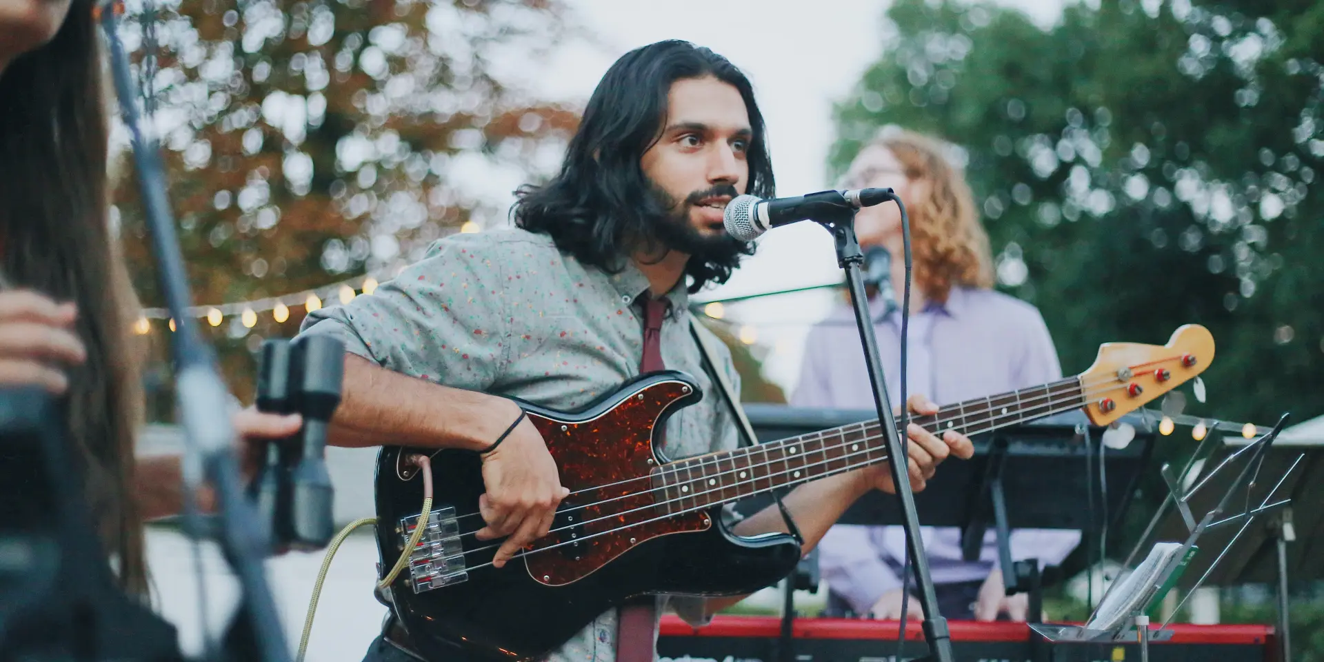 Un musicien jouant de la basse sur scène lors d'un concert en plein air