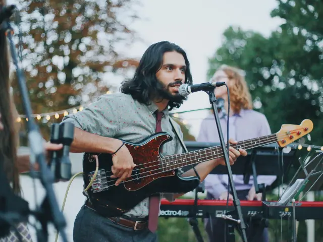 Un musicien jouant de la basse sur scène lors d'un concert en plein air