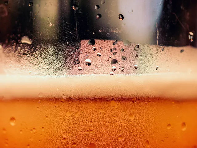 Gouttes de bière sur une vitre avec un arrière-plan flou