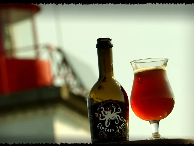 Bouteille de bière artisanale et verre de bière Captain James et ses mousses