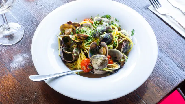 Un bol de pâtes aux palourdes avec des légumes