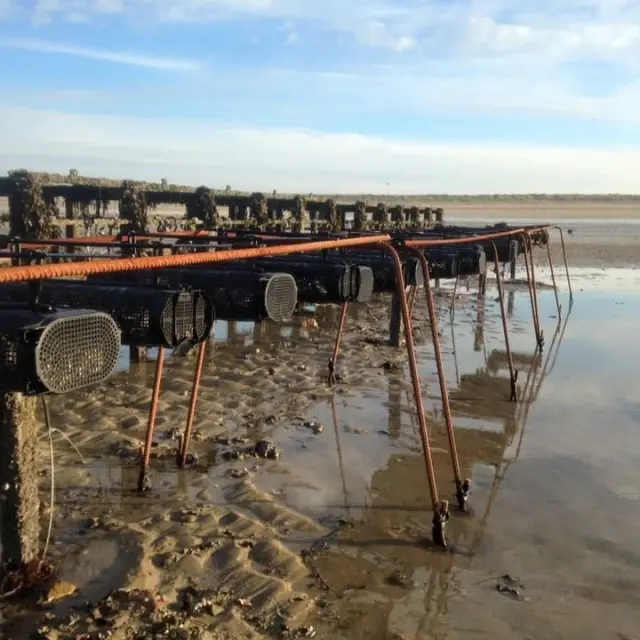 Rusty metal structure by the seaside with pipes and supports