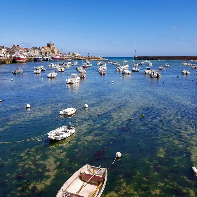 Bateaux de pêche amarrés dans un port avec des bâtiments en arrière-plan : Barfleur