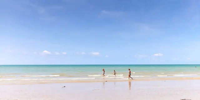 Trois enfants courant sur une plage de sable fin à Agon Coutainville