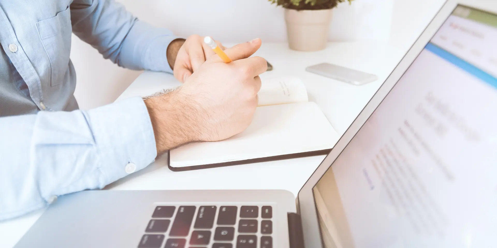 Personne travaillant sur un ordinateur portable avec un stylo