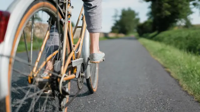 Pieds d'un cycliste en mouvement sur une route de campagne