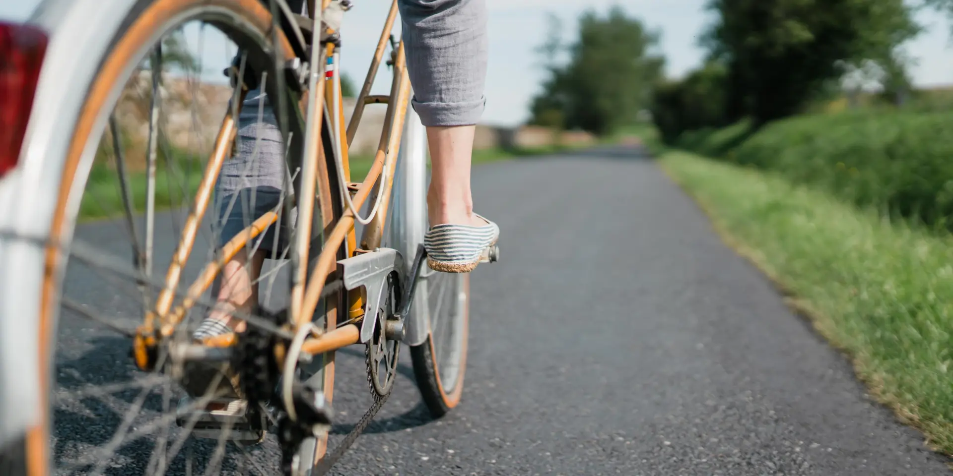 Pieds d'un cycliste en mouvement sur une route de campagne