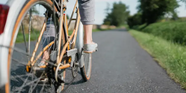 Pieds d'un cycliste en mouvement sur une route de campagne
