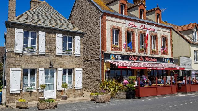 Rue avec un café et des bâtiments en pierre : Barfleur