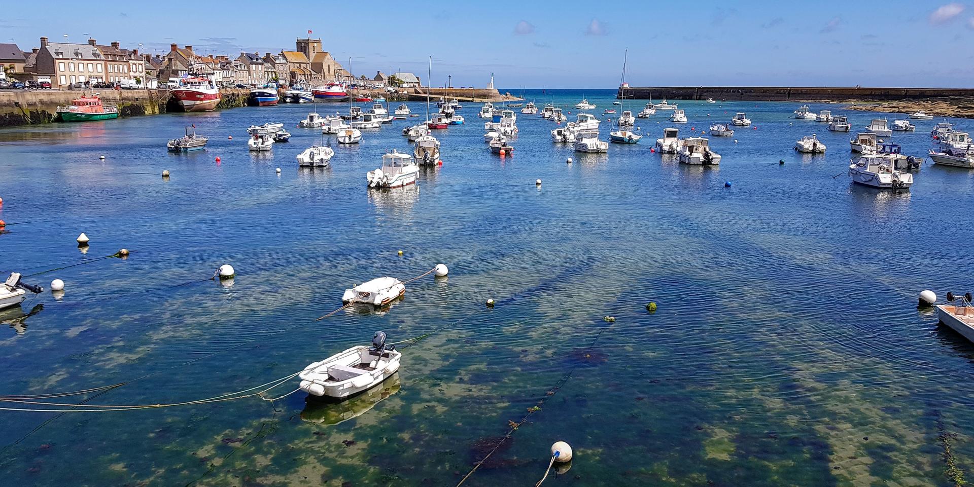 Bateaux de pêche amarrés dans un port avec des bâtiments en arrière-plan : Barfleur