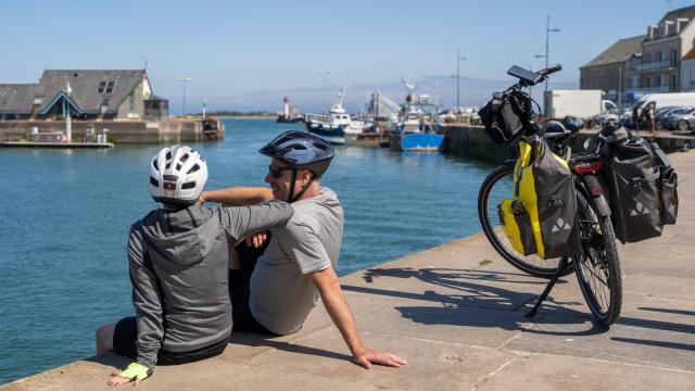 Deux cyclistes en pause près d'un plan d'eau avec des vélos équipés : Saint Vaast la Hougue