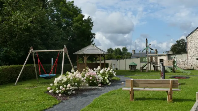 Aire de jeux avec balançoire, banc et structure à Courcy