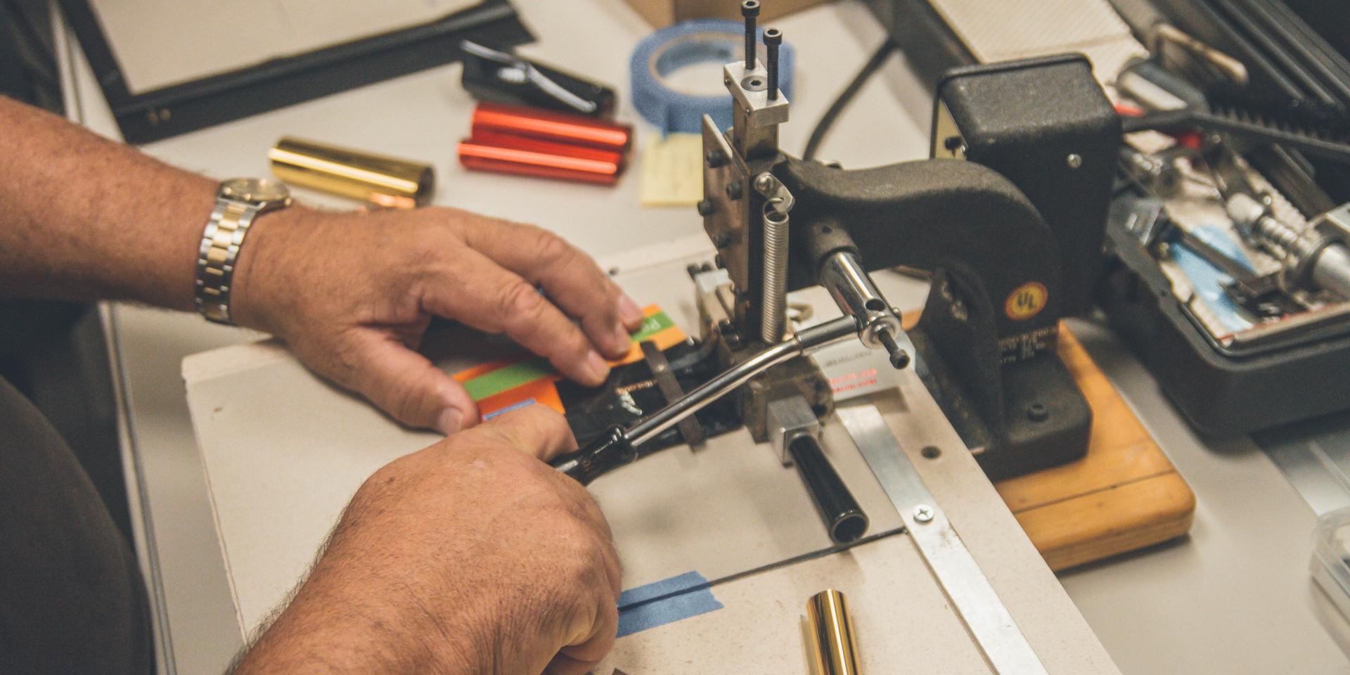 Un artisan manipule une machine de découpe avec précision