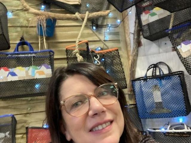 Femme souriante portant des lunettes et un manteau noir