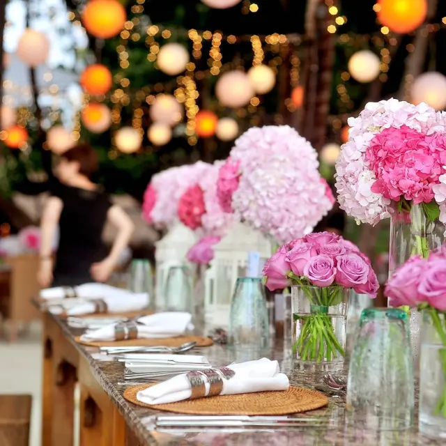 Table décorée avec des vases de fleurs roses et des couverts