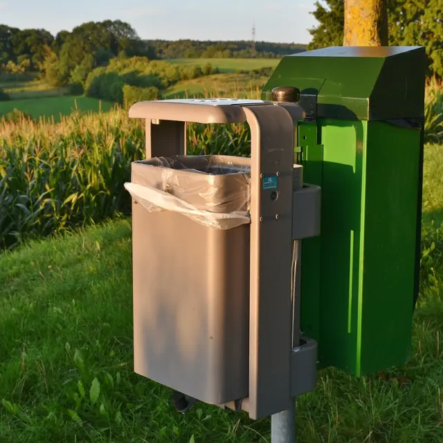 Zwei grüne und braune Mülltonnen auf einem Feld